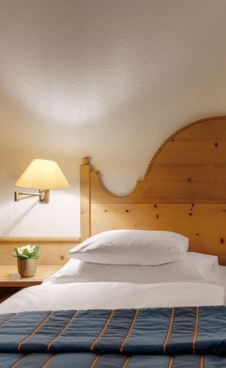 Großes Doppelbett im Haus Pöstli des Morosani Posthotels