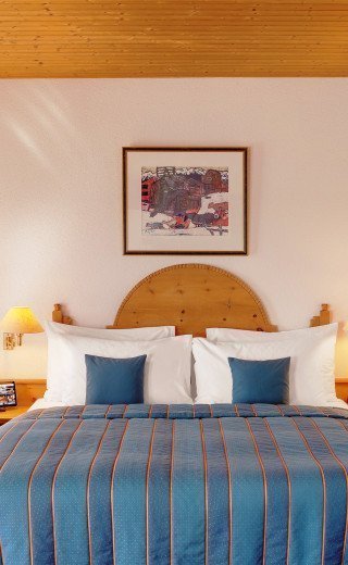 Großes Doppelbett in der Junior Suite des Posthotels in Davos