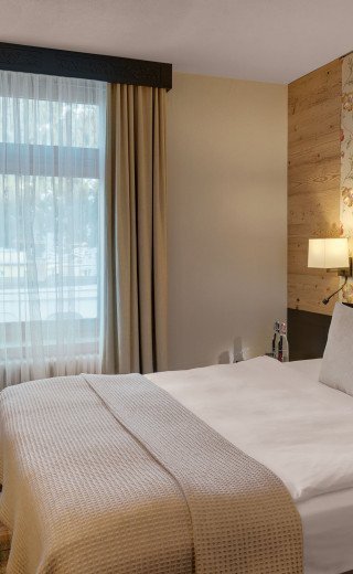 Großes Bett im Doppelzimmer Sport des Morosani "Schweizerhof" Hotels